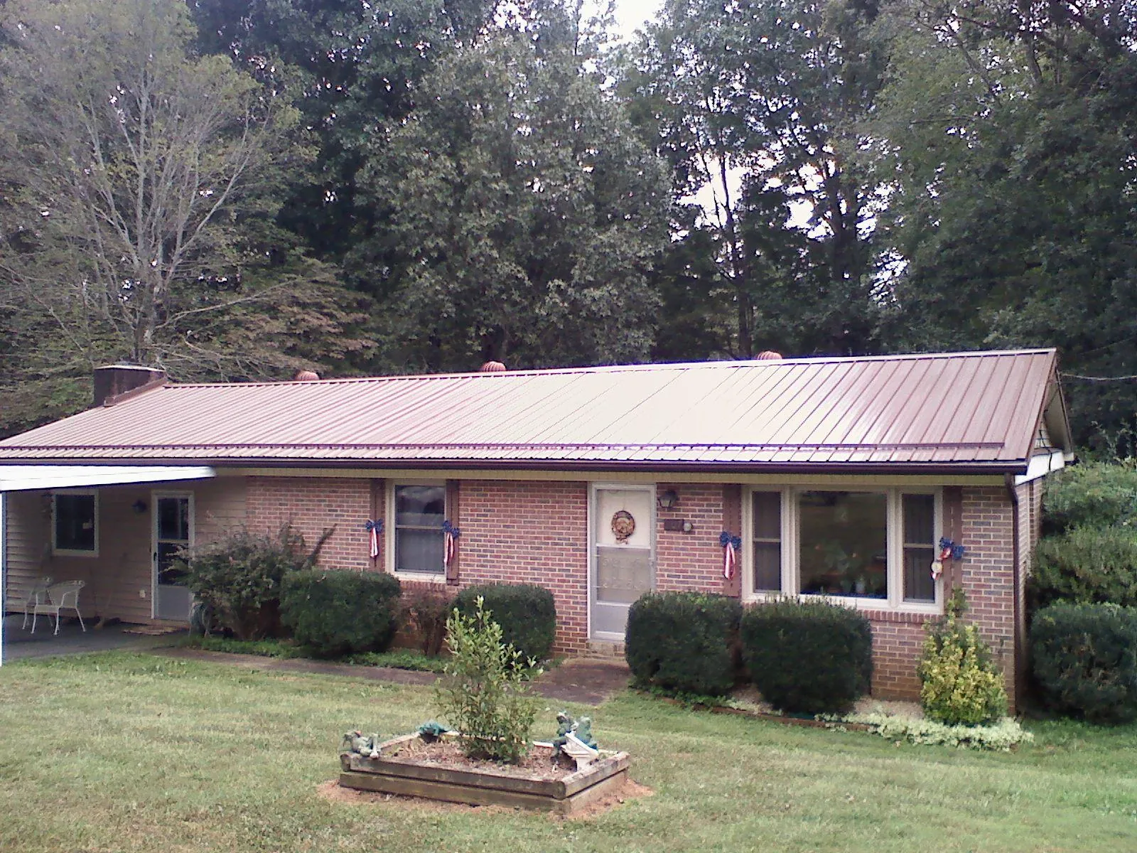 Bronze metal roof on a brick ranch home with a carport in Verona